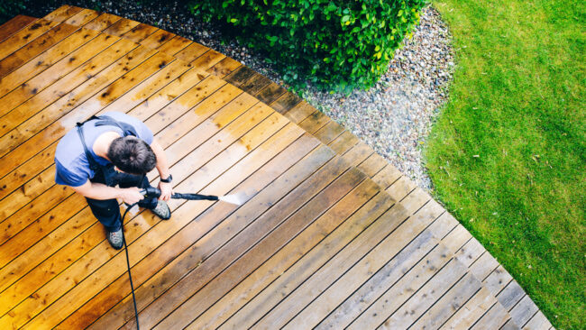 man cleaning terrace with a pressure washer