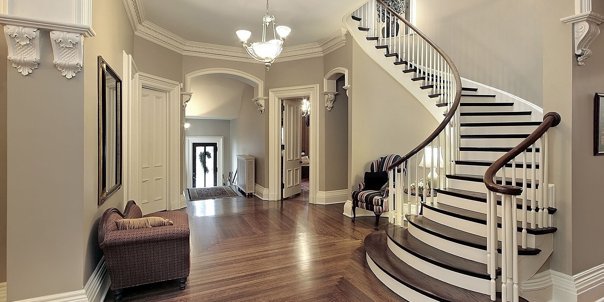 Foyer in traditional suburban home with curved staircase